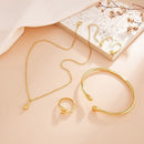 Conjunto de joias em formato de gota, composto por quatro peças em ouro ou prata: brincos, colar, pulseira e anel.